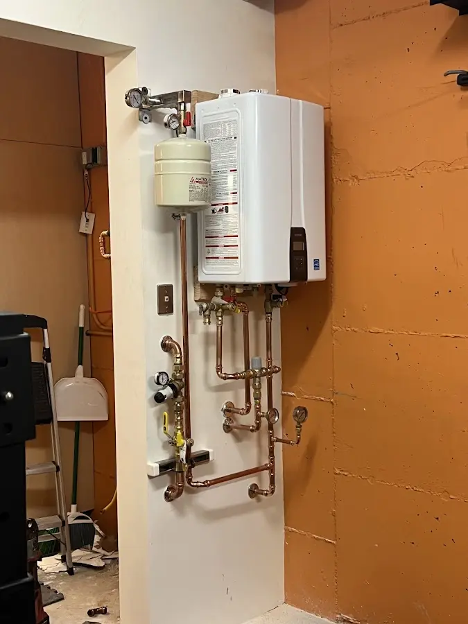Plumbing technician inspecting water heater connections in Enochville